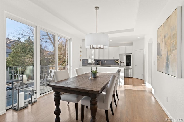 dining room with light wood finished floors and baseboards