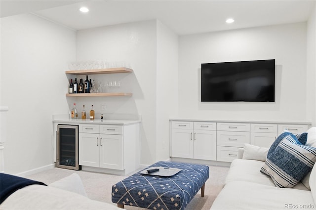 living area featuring recessed lighting, beverage cooler, light carpet, baseboards, and a bar