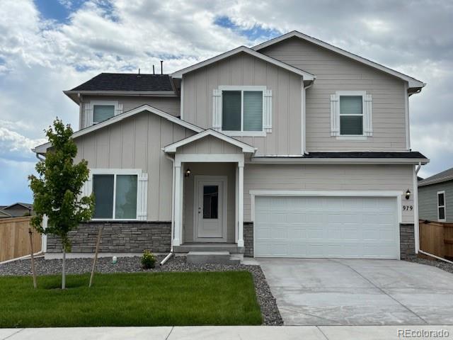 979 Cascade Falls St, Severance, CO 80550 - view of front facade with board and batten siding, a garage, concrete driveway, and stone siding