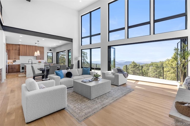 13415 S Resort Dr, Conifer, CO 80433 - living area featuring light wood finished floors, a high ceiling, and recessed lighting