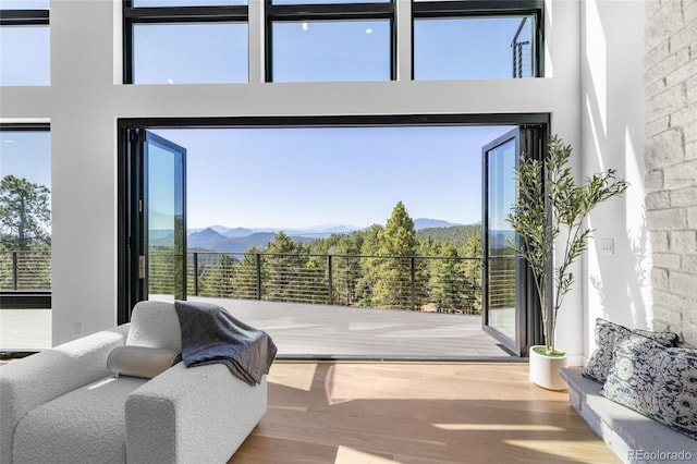 13415 S Resort Dr, Conifer, CO 80433 - bedroom with wood finished floors, multiple windows, a high ceiling, and a mountain view