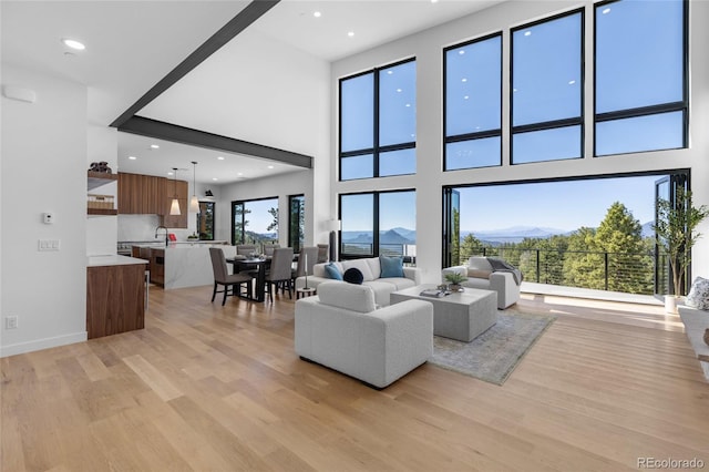 13415 S Resort Dr, Conifer, CO 80433 - living area with light wood finished floors, recessed lighting, a mountain view, and a towering ceiling