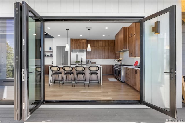13415 S Resort Dr, Conifer, CO 80433 - kitchen featuring premium appliances, modern cabinets, a kitchen breakfast bar, light wood-style flooring, and recessed lighting