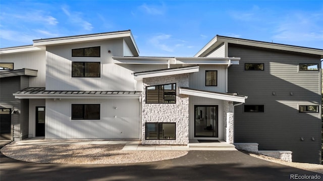 13415 S Resort Dr, Conifer, CO 80433 - view of front of house with stone siding, a standing seam roof, and a metal roof