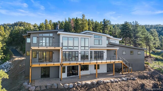 13415 S Resort Dr, Conifer, CO 80433 - back of house with a balcony, a patio area, stairs, and a forest view