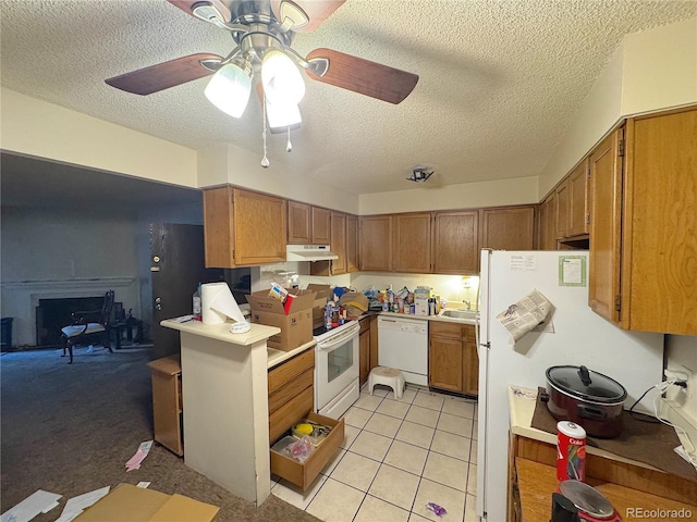 kitchen featuring brown cabinetry, white appliances, a textured ceiling, under cabinet range hood, and a ceiling fan