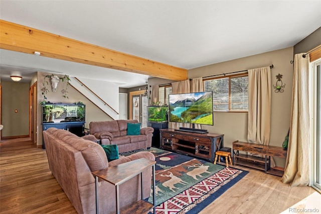 living area featuring beam ceiling and wood finished floors