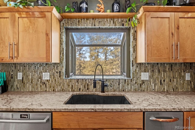 kitchen with dishwasher, light stone countertops, backsplash, and a sink