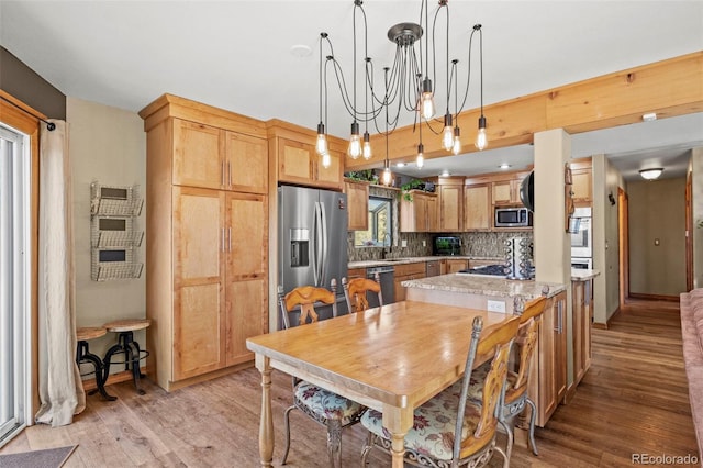 dining area featuring light wood-type flooring and an inviting chandelier