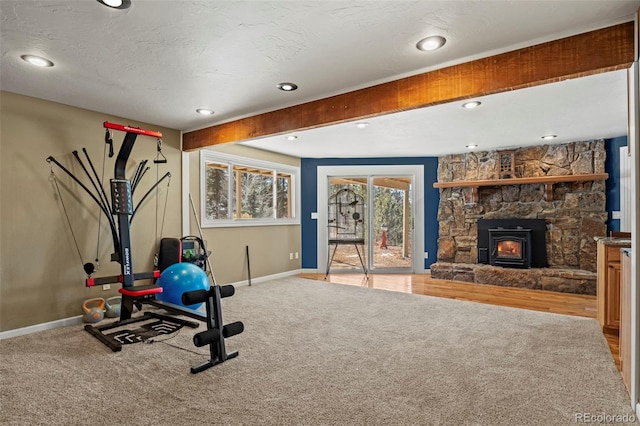 exercise room with baseboards, carpet floors, and a textured ceiling