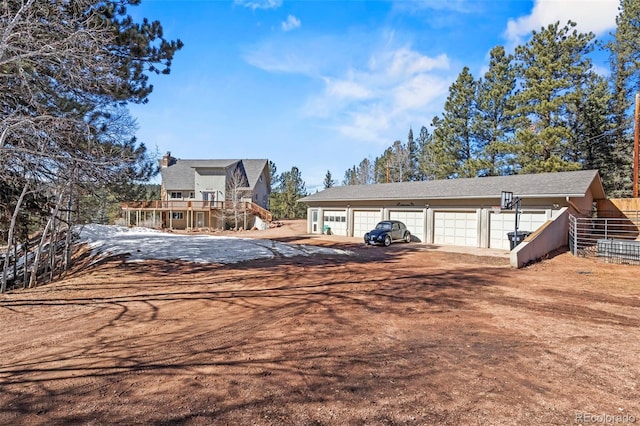 view of front of property with an outdoor structure, fence, and dirt driveway