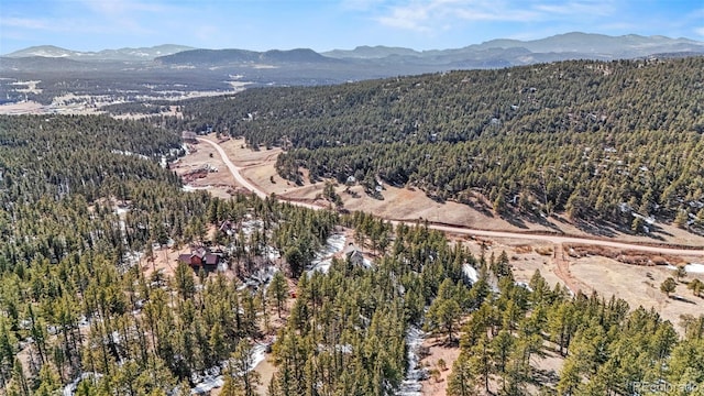 drone / aerial view with a mountain view and a forest view