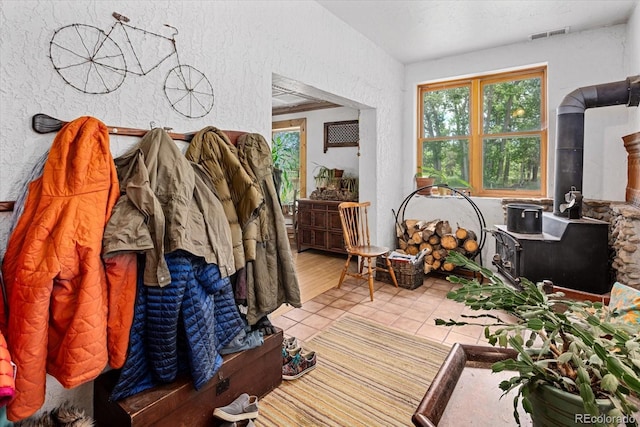 interior space with light tile patterned floors and a wood stove