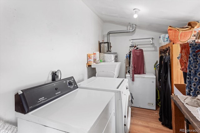 washroom with light hardwood / wood-style flooring and washing machine and clothes dryer