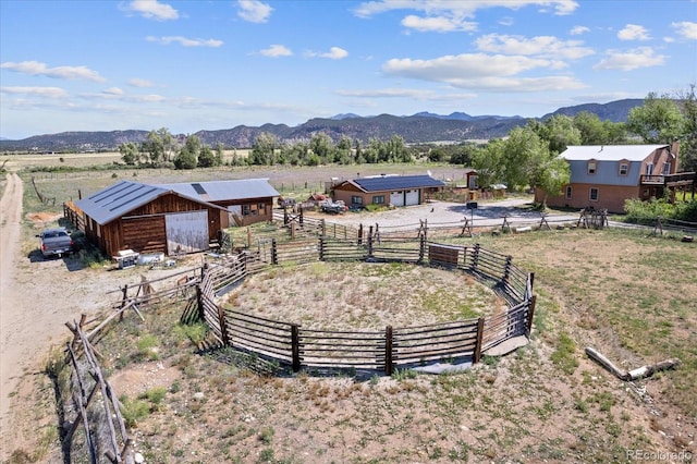 view of yard with an outbuilding, a mountain view, and a rural view