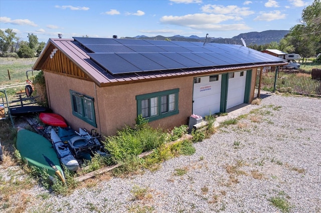 view of front of house featuring a mountain view and solar panels