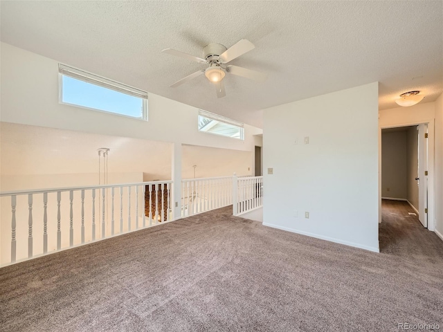 carpeted empty room featuring ceiling fan, a textured ceiling, and a healthy amount of sunlight