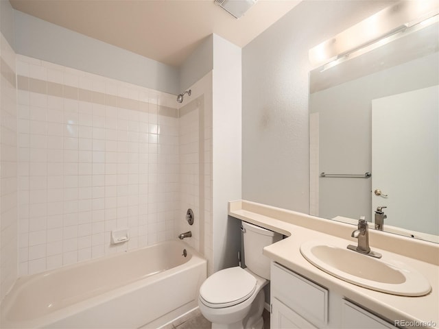 full bathroom featuring tiled shower / bath combo, vanity, and toilet