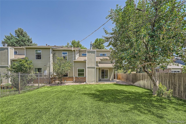 rear view of house featuring a yard