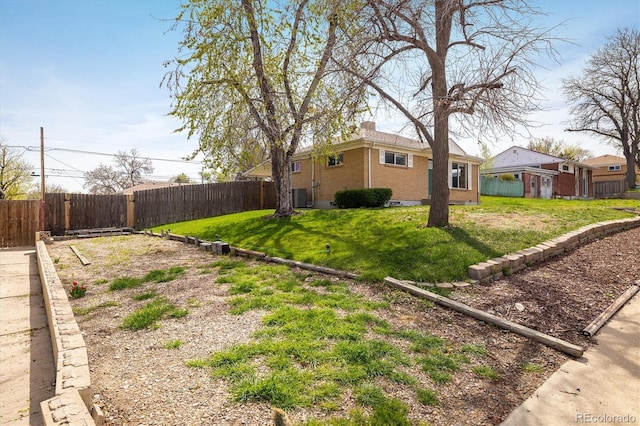 view of yard with central AC and fence