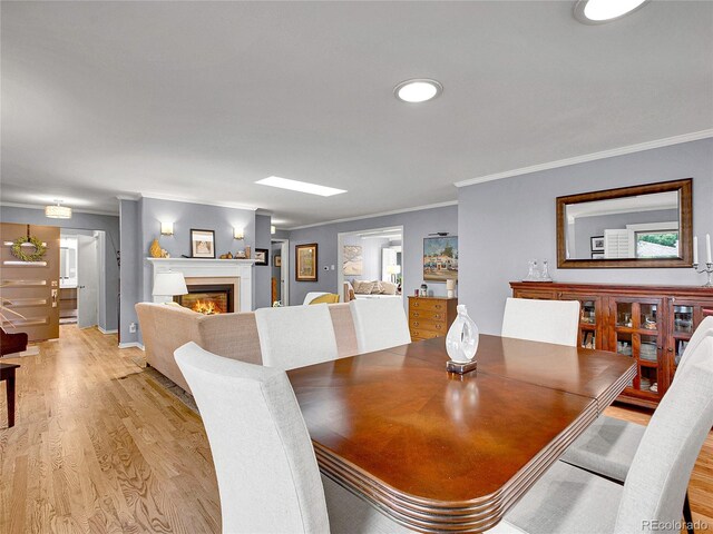 3481 S Race St, Englewood, CO 80113 - dining room with light wood finished floors, crown molding, a glass covered fireplace, and recessed lighting