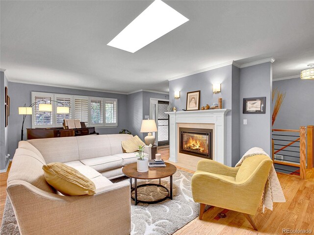 3481 S Race St, Englewood, CO 80113 - living room featuring ornamental molding, light wood finished floors, a fireplace with flush hearth, and a skylight