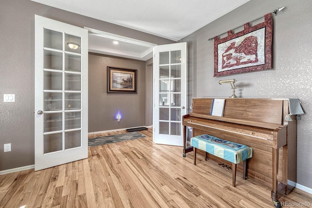 miscellaneous room with light hardwood / wood-style floors and french doors