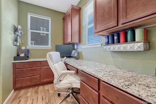 home office featuring light wood-type flooring and built in desk