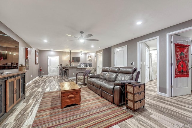 living room with light wood-type flooring and ceiling fan