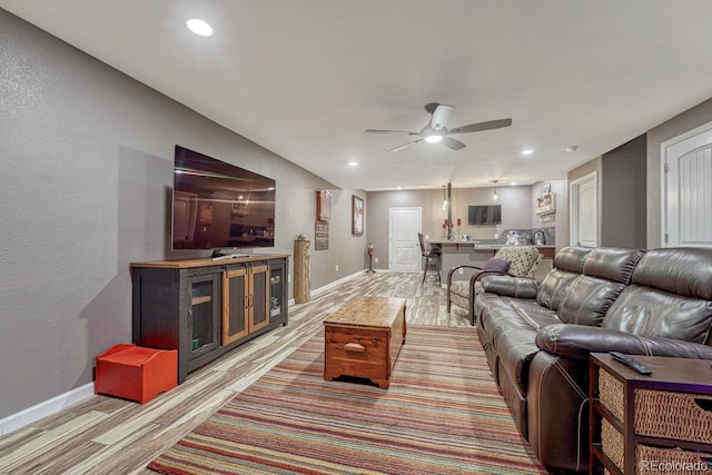 living room with light wood-type flooring and ceiling fan