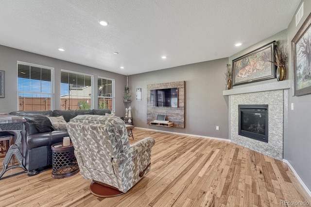 living room with a textured ceiling and light hardwood / wood-style flooring