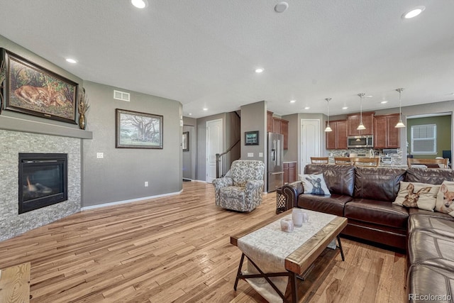 living room featuring light wood-type flooring and a textured ceiling