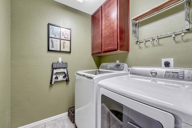 washroom with washer and clothes dryer, cabinets, and light tile patterned flooring