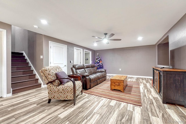 living room featuring ceiling fan and light hardwood / wood-style flooring