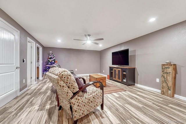 living room featuring light hardwood / wood-style flooring and ceiling fan