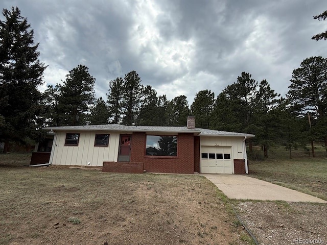 1013 Lexington Ln, Estes Park, CO 80517 - ranch-style house with board and batten siding, a garage, concrete driveway, and a chimney