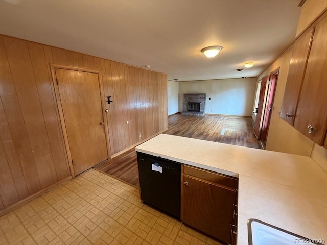 1013 Lexington Ln, Estes Park, CO 80517 - kitchen with light countertops, wooden walls, a fireplace with raised hearth, a peninsula, and dishwasher