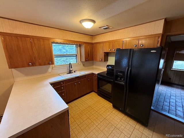 1013 Lexington Ln, Estes Park, CO 80517 - kitchen with black appliances, brick patterned flooring, light countertops, and brown cabinetry