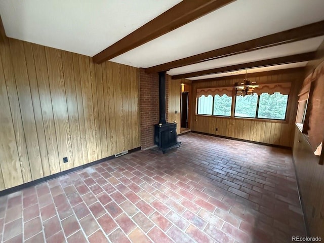 1013 Lexington Ln, Estes Park, CO 80517 - unfurnished living room featuring a wood stove, wooden walls, brick flooring, and beamed ceiling