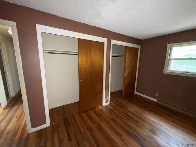 1013 Lexington Ln, Estes Park, CO 80517 - unfurnished bedroom featuring wood finished floors, two closets, and a textured ceiling