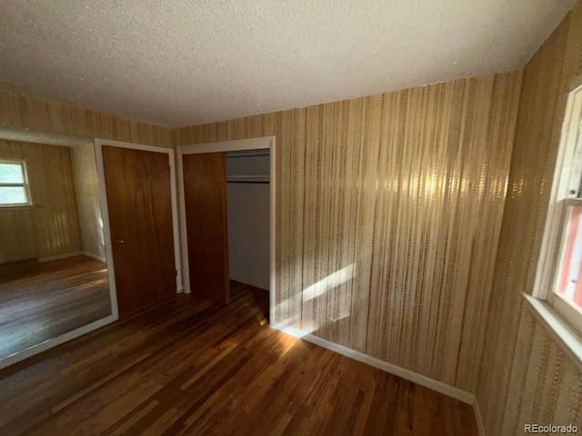 1013 Lexington Ln, Estes Park, CO 80517 - unfurnished bedroom featuring wood finished floors, a textured ceiling, wallpapered walls, and a closet
