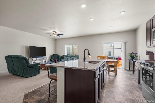 1868 Homestead Dr, Fort Lupton, CO 80621 - kitchen with a sink, stainless steel electric stove, a breakfast bar area, plenty of natural light, and recessed lighting