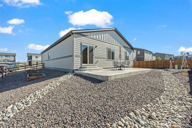 1868 Homestead Dr, Fort Lupton, CO 80621 - rear view of house with fence, a patio, and board and batten siding