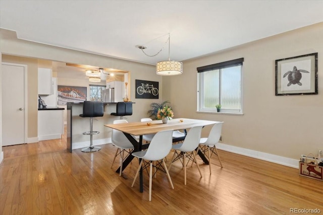 dining room featuring baseboards and light wood-style floors