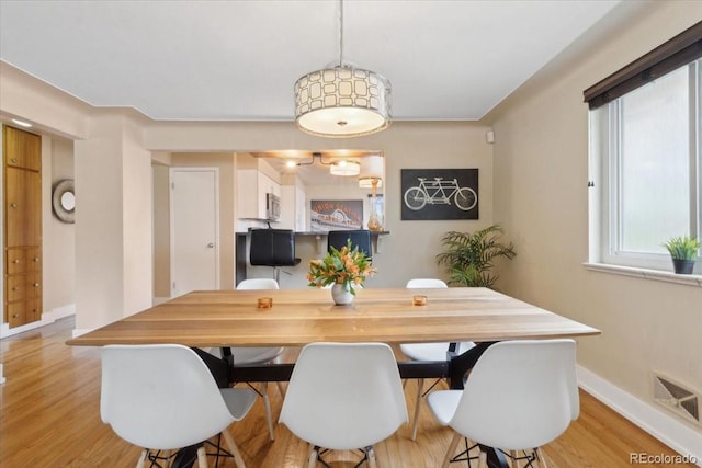dining room featuring visible vents, baseboards, and light wood-type flooring