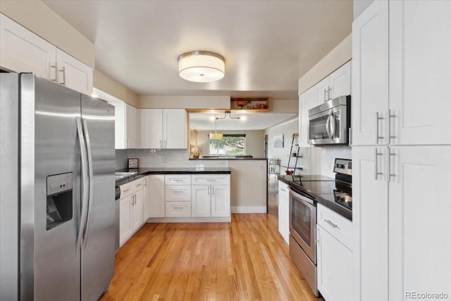 kitchen with tasteful backsplash, white cabinets, dark countertops, and stainless steel appliances