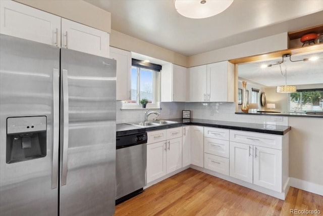 kitchen featuring a healthy amount of sunlight, white cabinetry, a sink, and appliances with stainless steel finishes