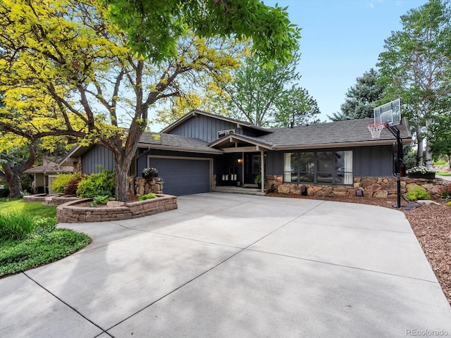 7055 E Heritage Pl S, Centennial, CO 80111 - view of front of house featuring board and batten siding, driveway, stone siding, and a garage