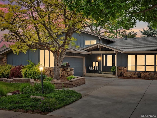 7055 E Heritage Pl S, Centennial, CO 80111 - view of front of home with board and batten siding, stone siding, concrete driveway, and a garage