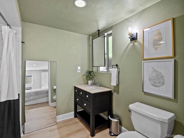 7055 E Heritage Pl S, Centennial, CO 80111 - bathroom featuring toilet, vanity, wood finished floors, ensuite bath, and a textured ceiling